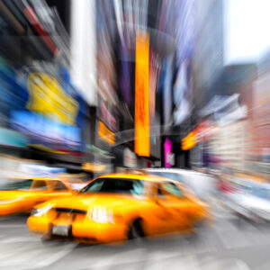 Motion blur photo of yellow taxi cabs rushing on Broadway road in Times Square during rush hour in midtown Manhattan, New York City, New York USA.Colorful abstract background. No people. Copy space