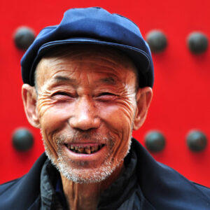 Portrait of a happy active senior adult Chinese man visiting at the Forbidden City in Beijing, China.