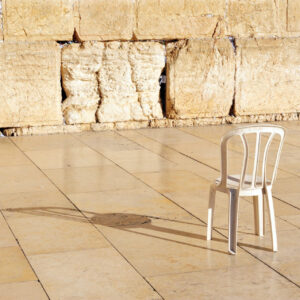 An empty chair at the Kotel Wailing Western Wall, a remnant of the ancient wall that surrounded the Jewish Temple's the most sacred site recognized by the Jewish faith outside of the Temple Mountain.