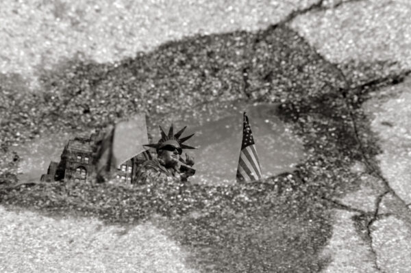 Liberty Sinking -Reflection in water puddle after rain of Statue of liberty Living statue in Battery Park in lower Manhattan, New York City, USA – Fine Arts Photography print for sale. Decoration poster of home or office wall taken by documentary travel photographer Rafael Ben Ari