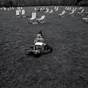 Heartbroken British black man lying on grass St. James's Park Westminster, central London UK