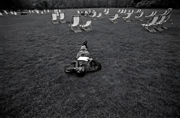 Heartbroken British black man lying on grass St. James's Park Westminster, central London UK