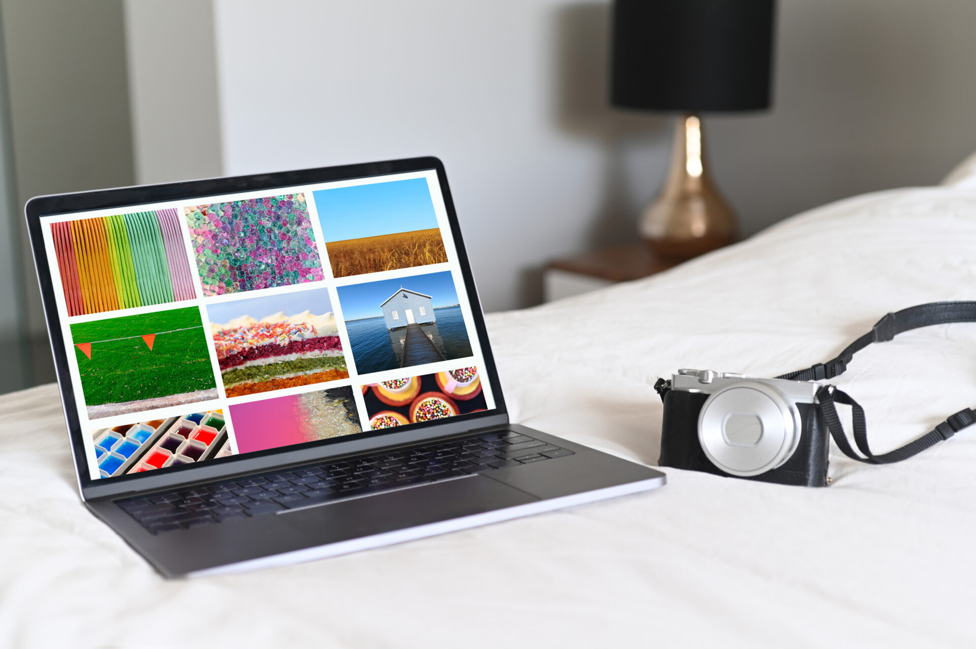 Laptop and camera on a bed. Concept photo of travel photography ,blogging and photographer working from hotel room or home.