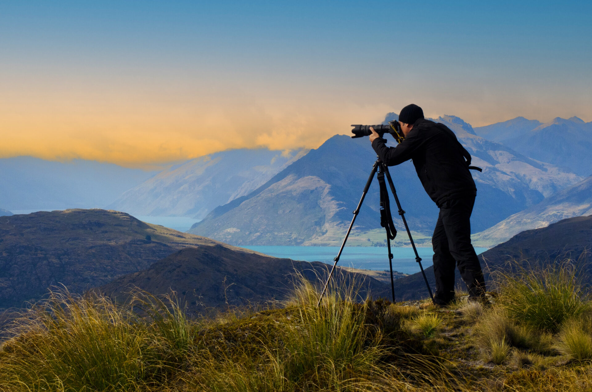 Documentary travel photographer Rafael Ben Ari photographing the landscape view of the Remarkables and Lake Wakatipu in the South Island of New Zealand.